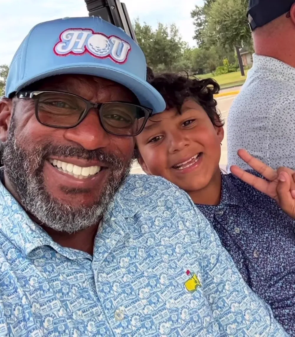 Golfer and junior golfer smiling in a golf cart