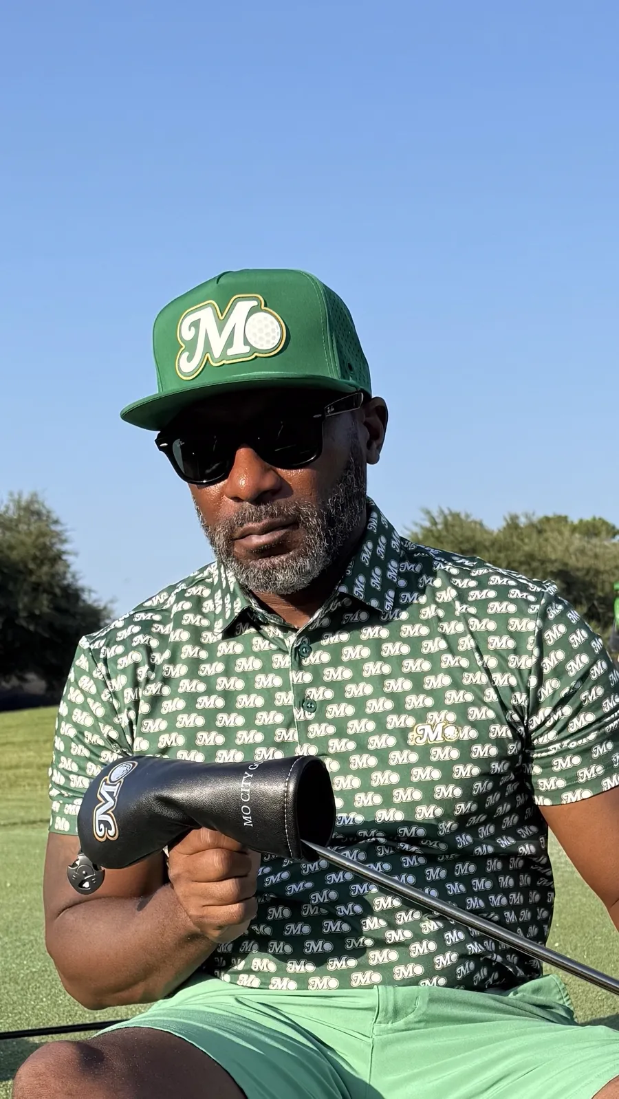 Golfer in a Mo City polo and green Mo hat