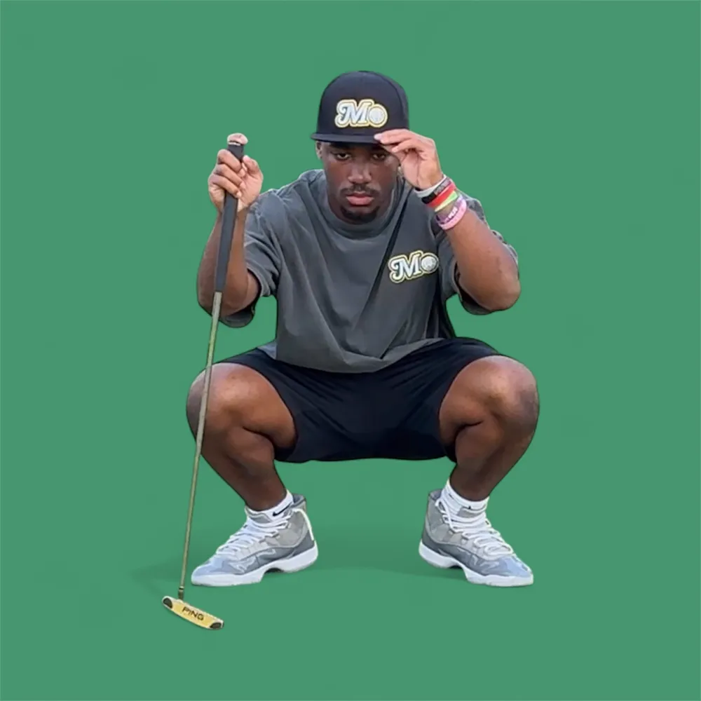 Golfer in a black Mo hat reading a putt