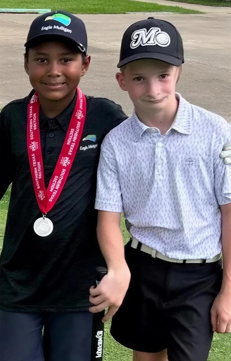 Two junior golfers, one wearing a tournament medal