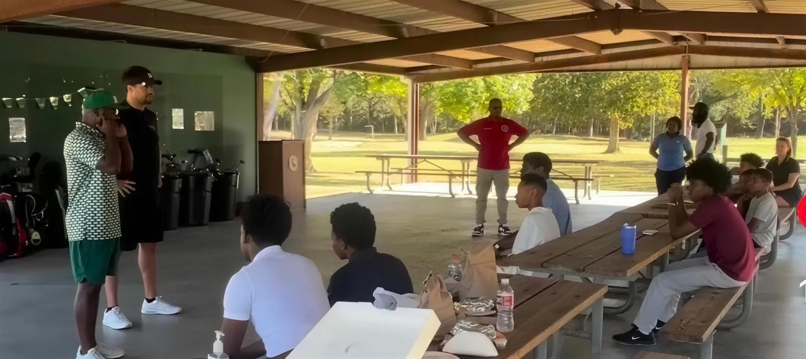Juniors listening to a talk under the clubhouse pavilion